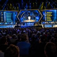 Large esports arena crowd facing a lit stage with giant screens displaying player stats and a trophy graphic during a Counter-Strike tournament