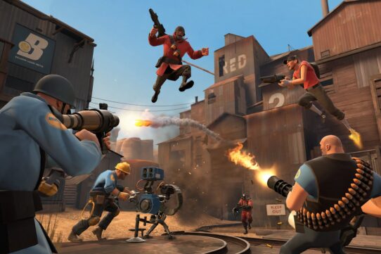 Team Fortress 2 promotional artwork showing RED and BLU team characters battling in an industrial setting with weapons and explosions