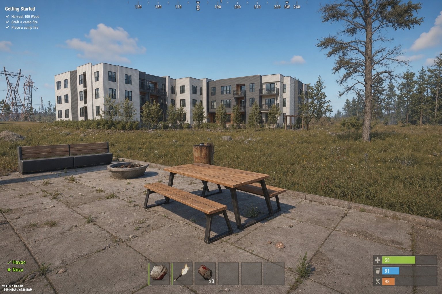 Rust gameplay screenshot showing a picnic table on a concrete patio near a multi-story building, with Getting Started tutorial objectives visible